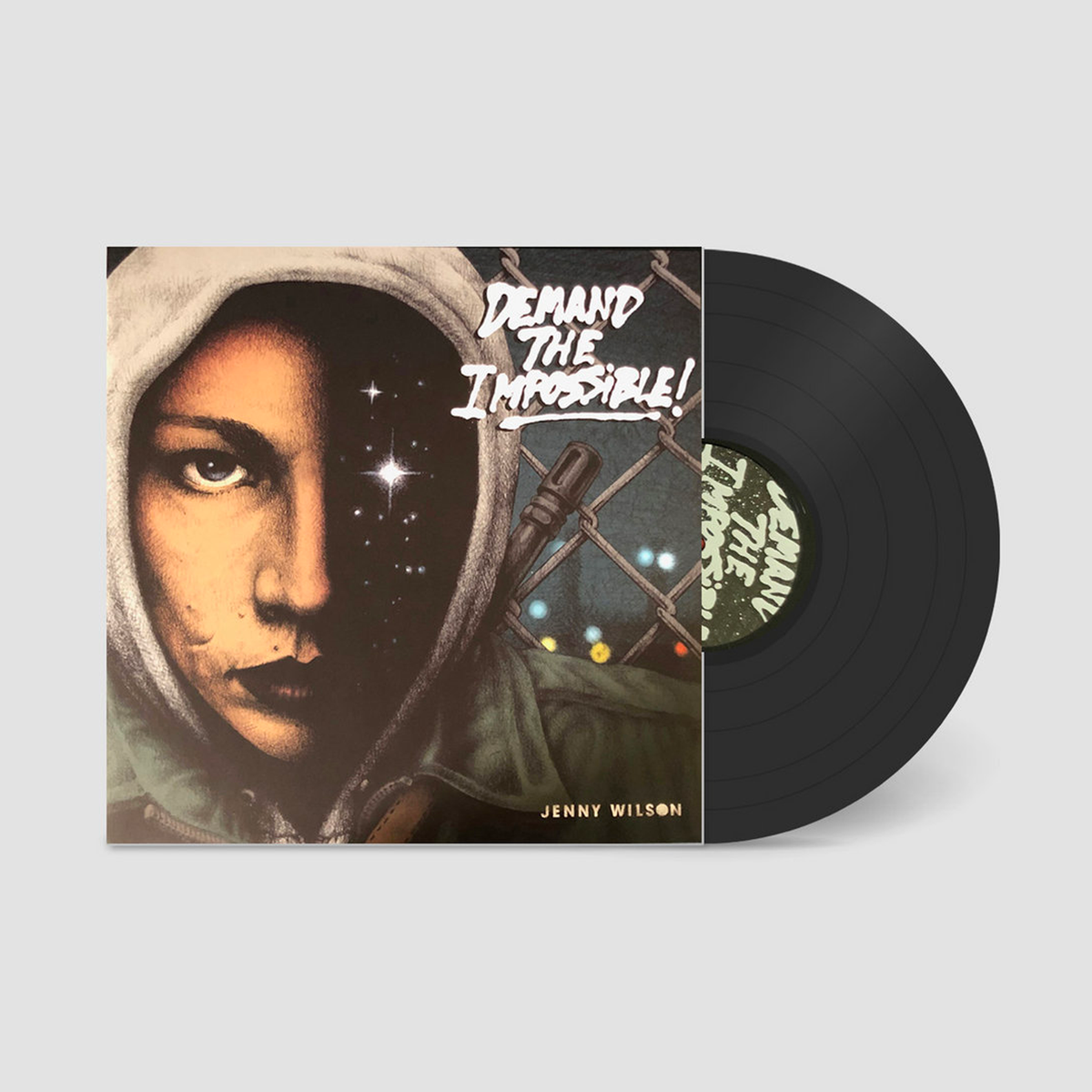 Album cover image for “Demand the Impossible!” by Jenny Wilson, featuring a close-up portrait of the artist in a hooded jacket against a chain-link fence
