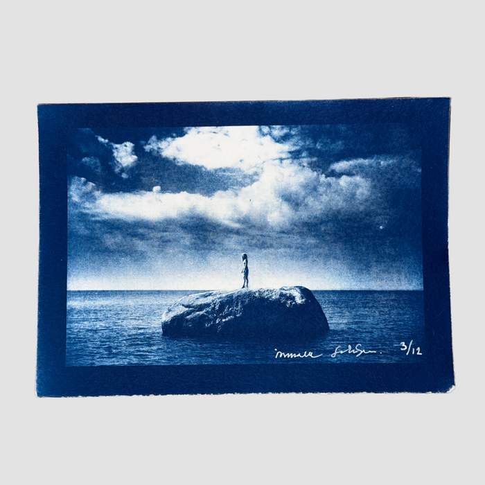 Cyanotype depicting ionnalee standing on a rock in a lake, by John Strandh